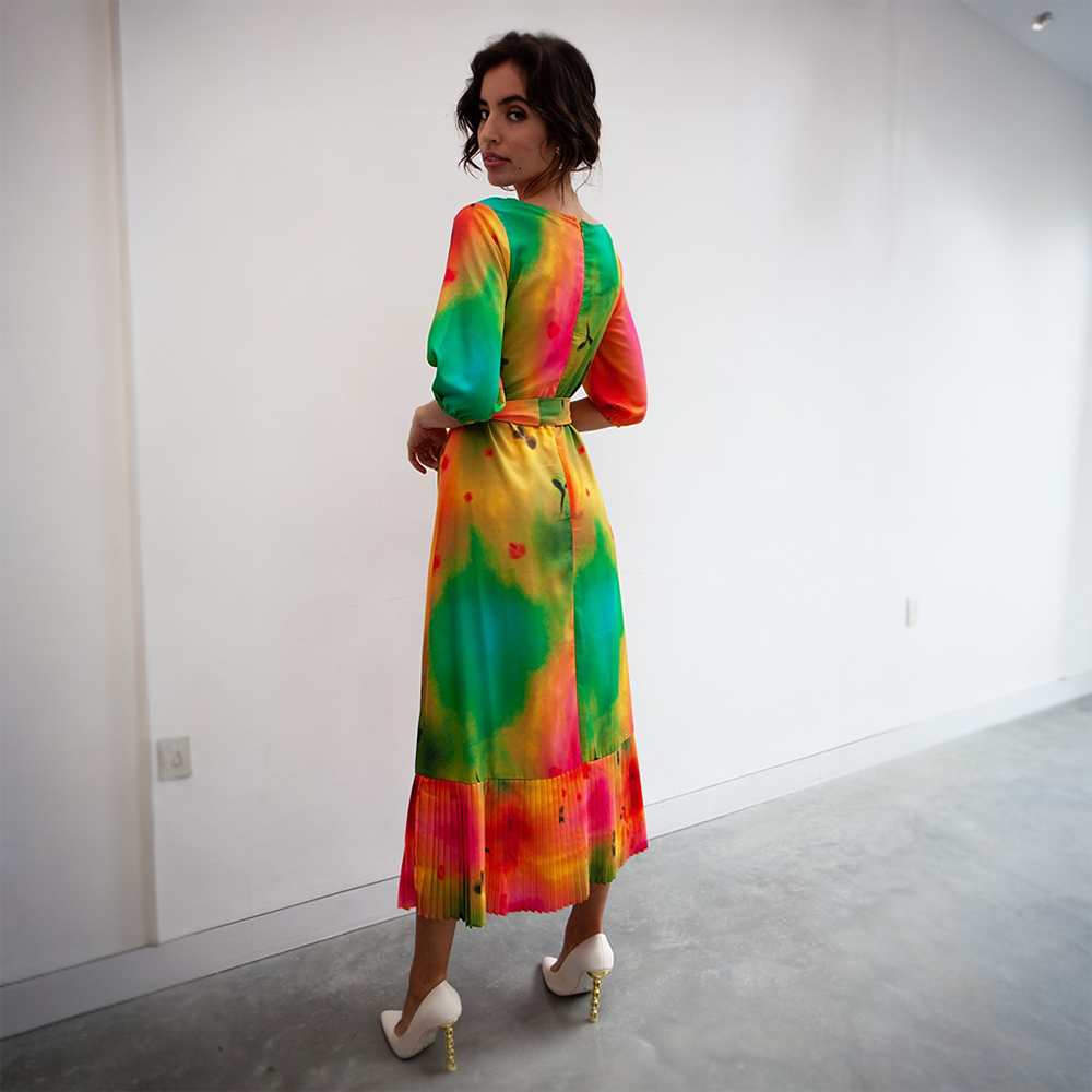 This breathtaking dress features greens, yellows and reds, three quarter length sleeves, and a partially pleated skirt.