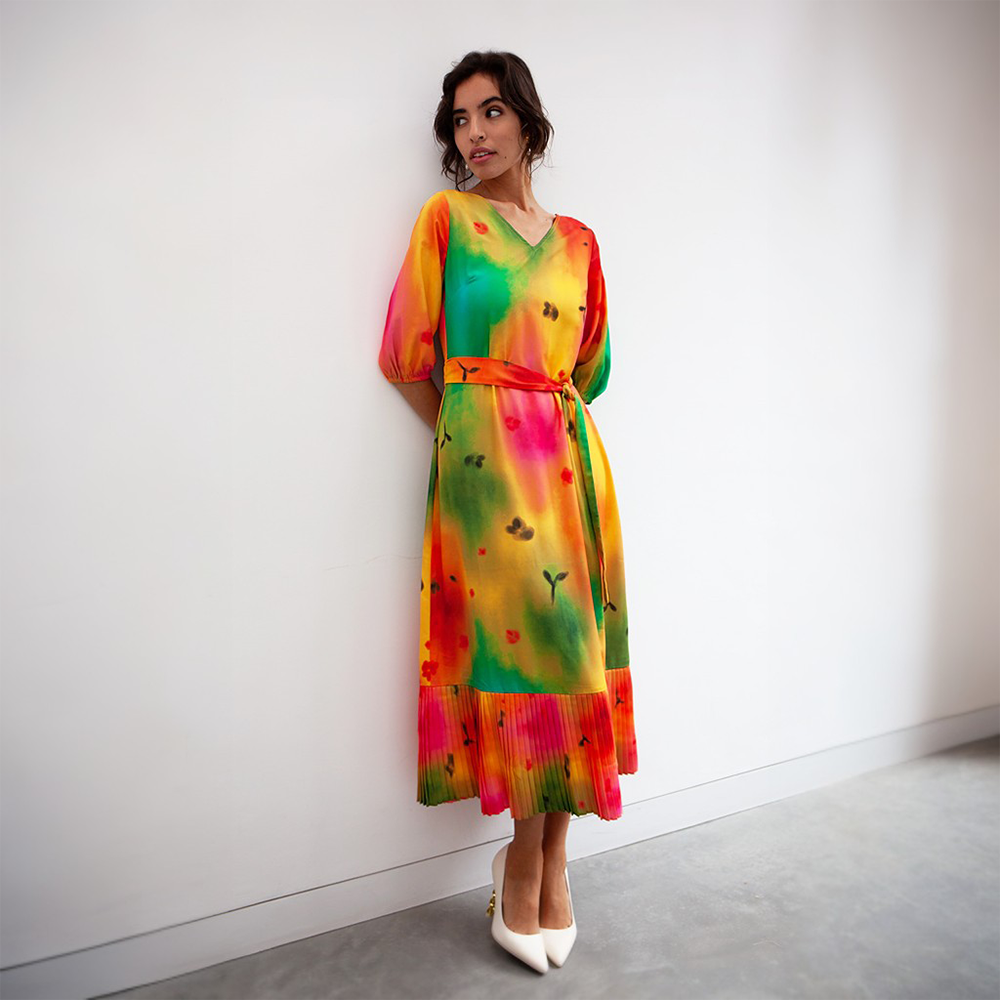 This breathtaking dress features greens, yellows and reds, three quarter length sleeves, and a partially pleated skirt.