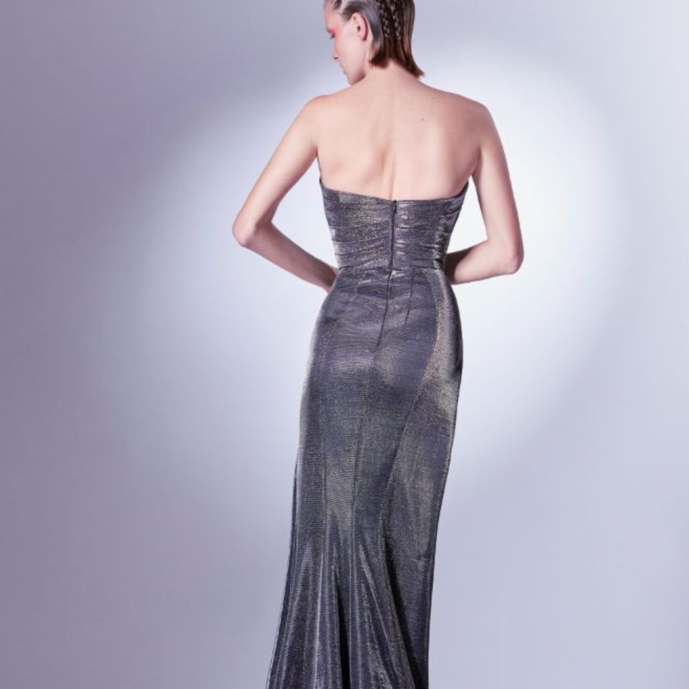 The constructed asymmetrical bodice highlights the feminine figure, as the folds in the skirt drop in tandem to the floor. 