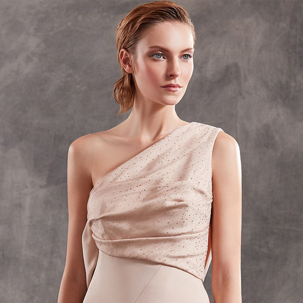 One shoulder gown in silk crepe with tulle details and drapings.