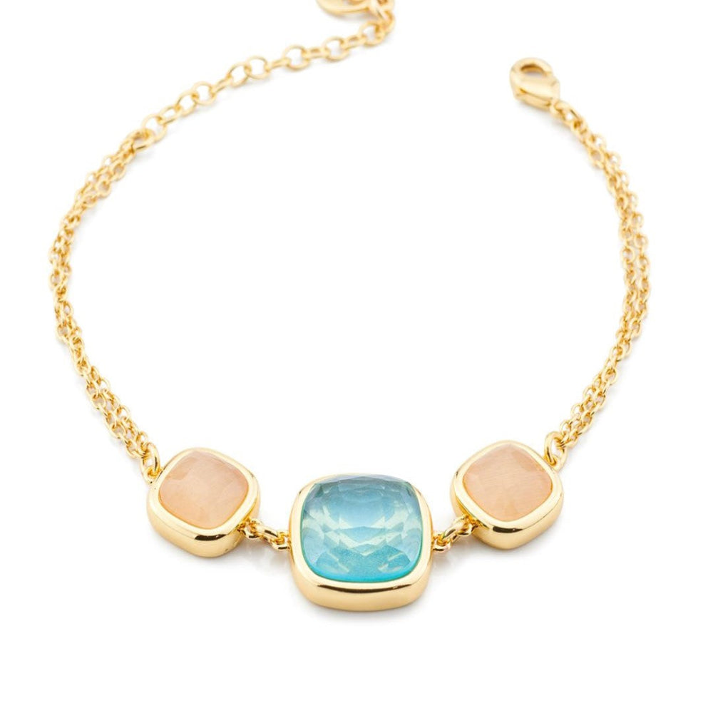 Yellow gold plated bracelet with a striking aquamarine crystal and peach-toned crystal accents for a stylish modern touch. Shop premium jewelry online.