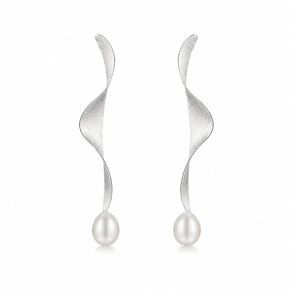 Discover the Moontide Sterling Silver Pearl Drop Earrings at The Luxe Maison, featuring sculptural, ribbon-like sterling silver designs finished with luminous pearls. Inspired by the gentle movement of ocean tides beneath moonlight, these elegant earrings combine fluid shapes with a soft, timeless glow. Perfect for special occasions or refined everyday styling, they bring graceful movement and understated sophistication to any look.