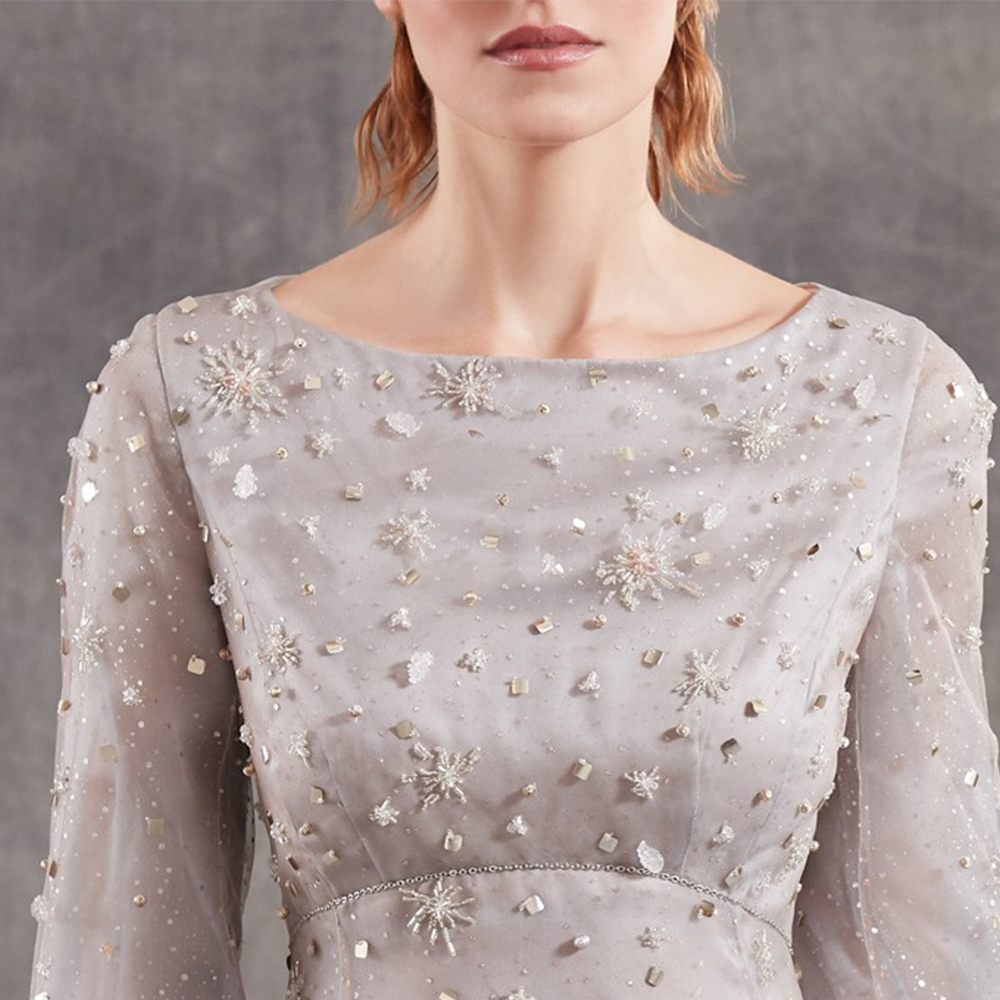It is a beautiful longuette dress in silk organza with laminated polka dots tulle inserts and long sleeves