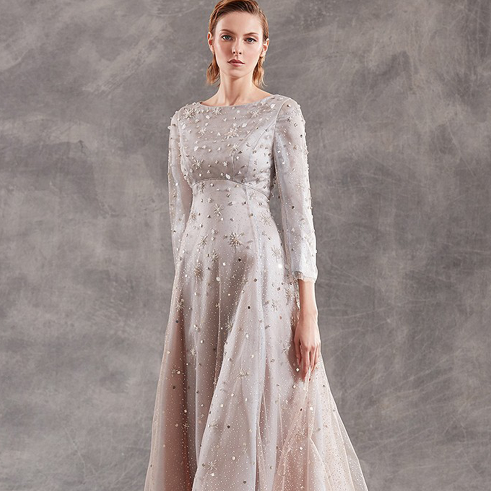 It is a beautiful longuette dress in silk organza with laminated polka dots tulle inserts and long sleeves