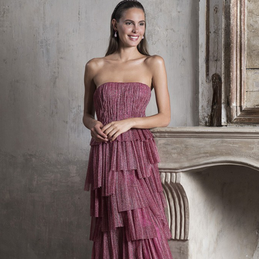 Strapless column gown in pleated metallic tulle with asymmetric flounced skirt.