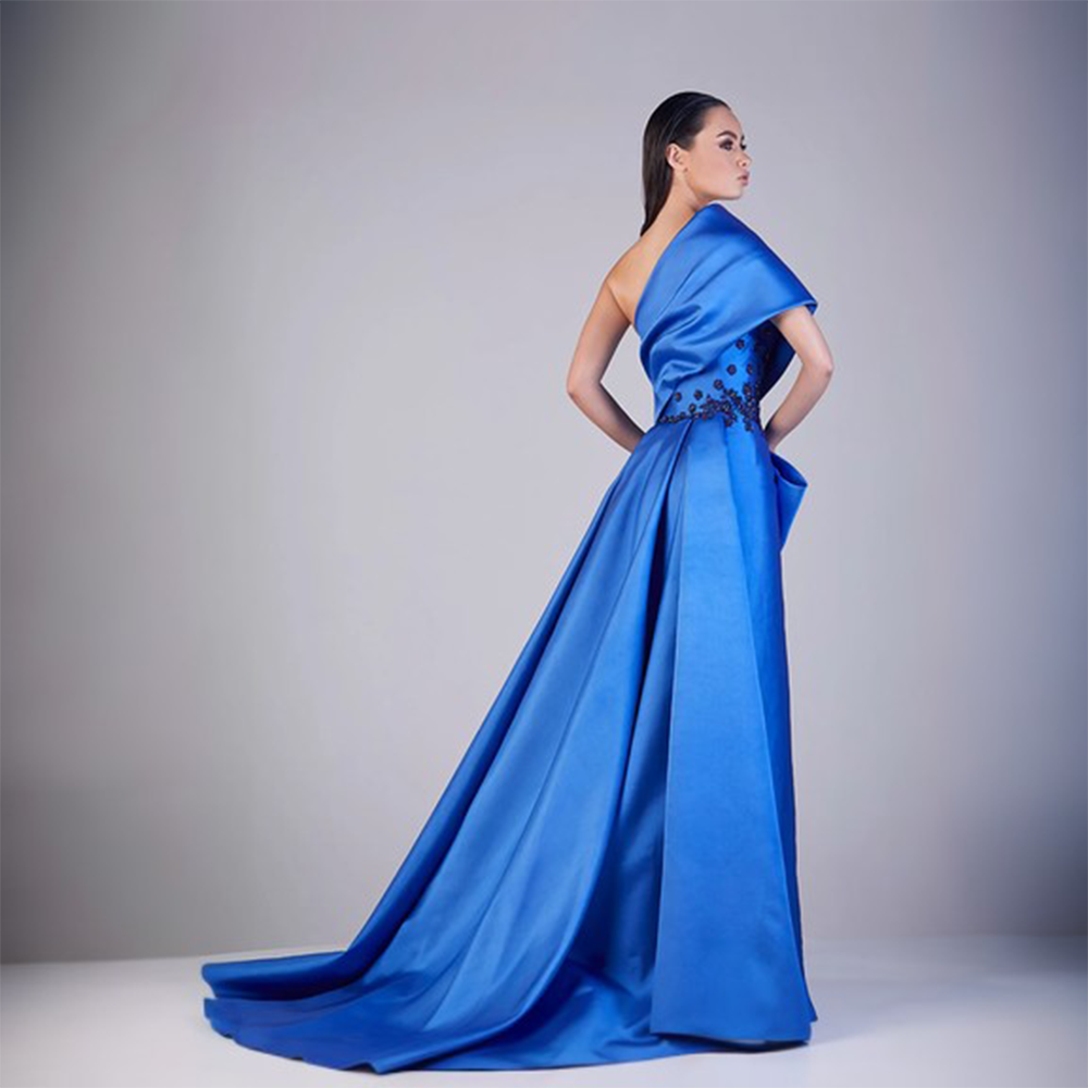 Off shoulder and one sided sleeve dramatic trail gown with front side slit open and side twisted bow look. 