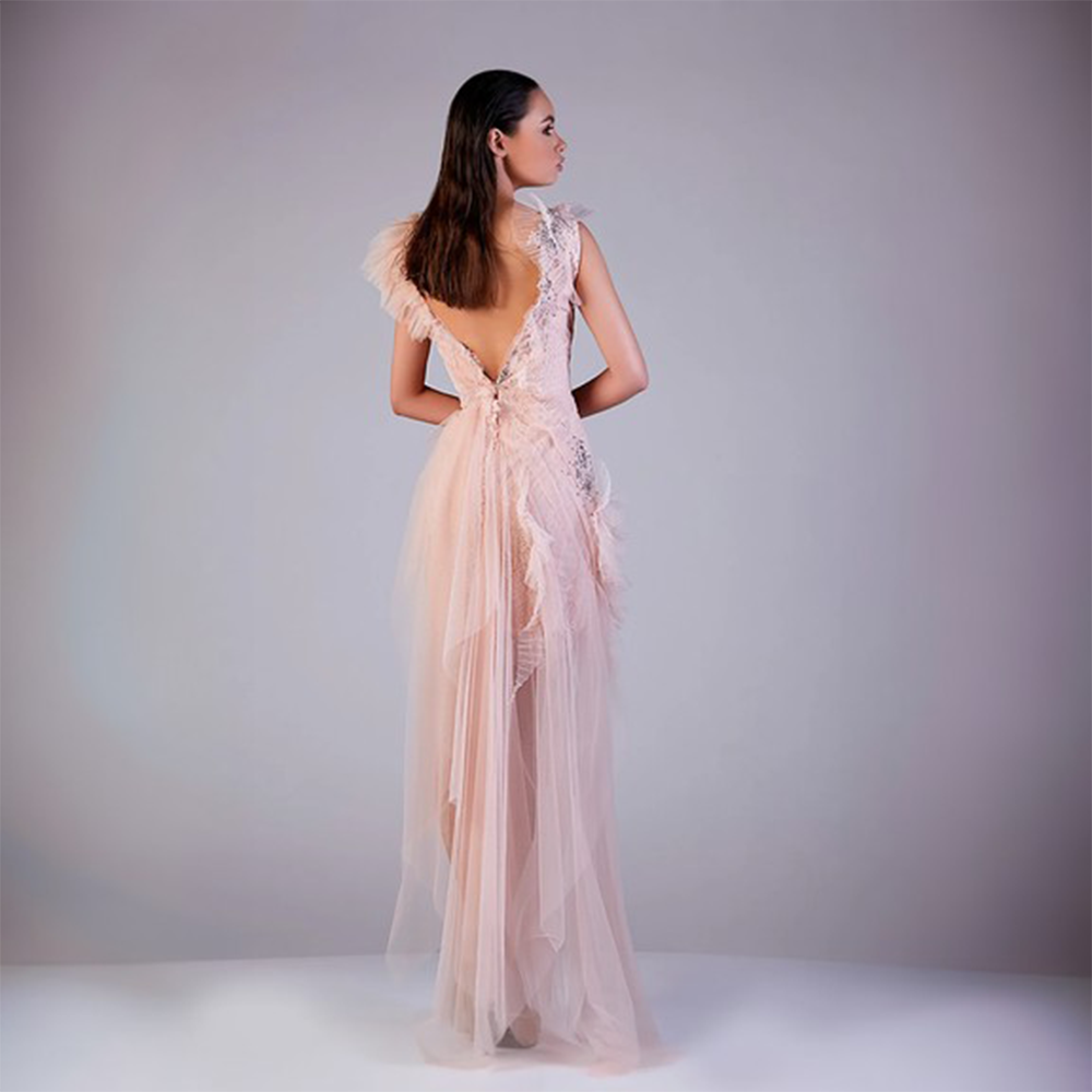 Fitted bodice with frills at the neck and sleeves connected with high low tulle skirt. 