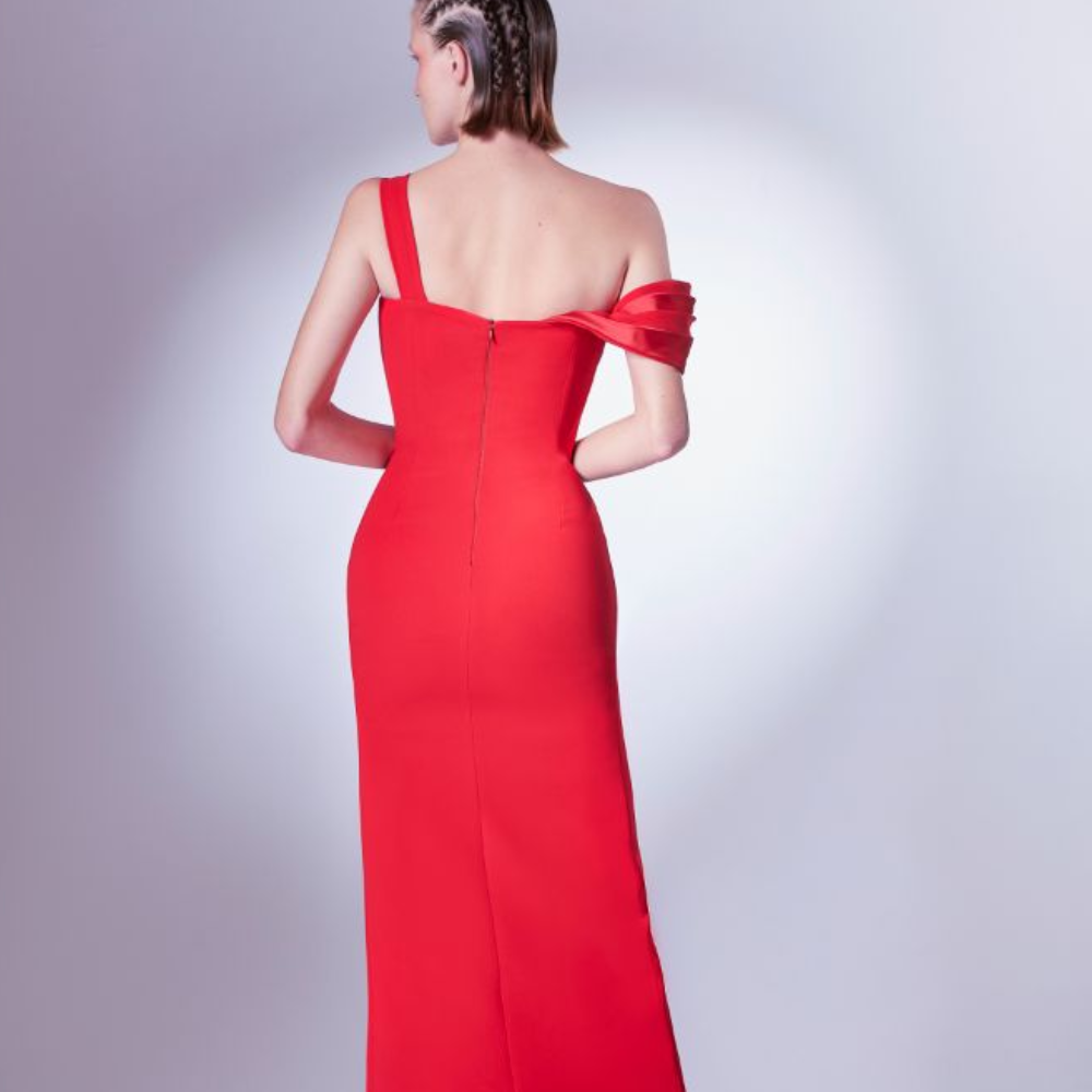 Geometrically constructed in satin folds, the bust elegantly rises on one shoulder and dops asymmetrically on the other. 