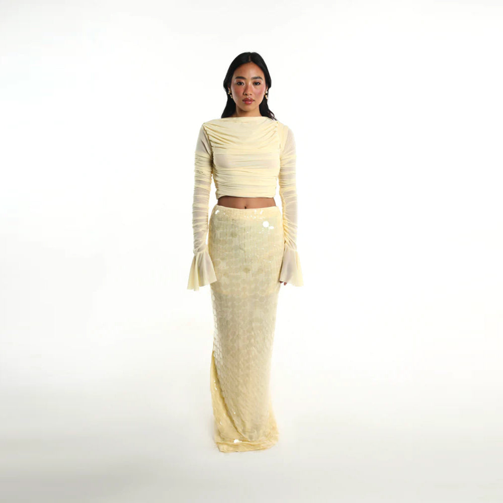 Pastel yellow set with ruched mesh top and sequin skirt, perfect for parties. Shop online from our curated edit of premium fashion.