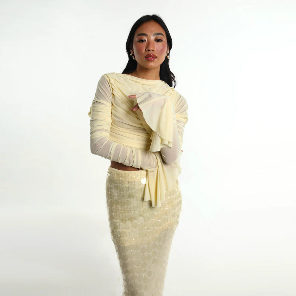 Pastel yellow set with ruched mesh top and sequin skirt, perfect for parties. Shop online from our curated edit of premium fashion.