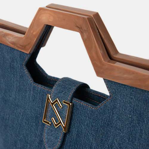 Made out of 35% recycled cotton denim, 35% recycled plastic fabric, 10% resin handle, 20% gold plated brass.