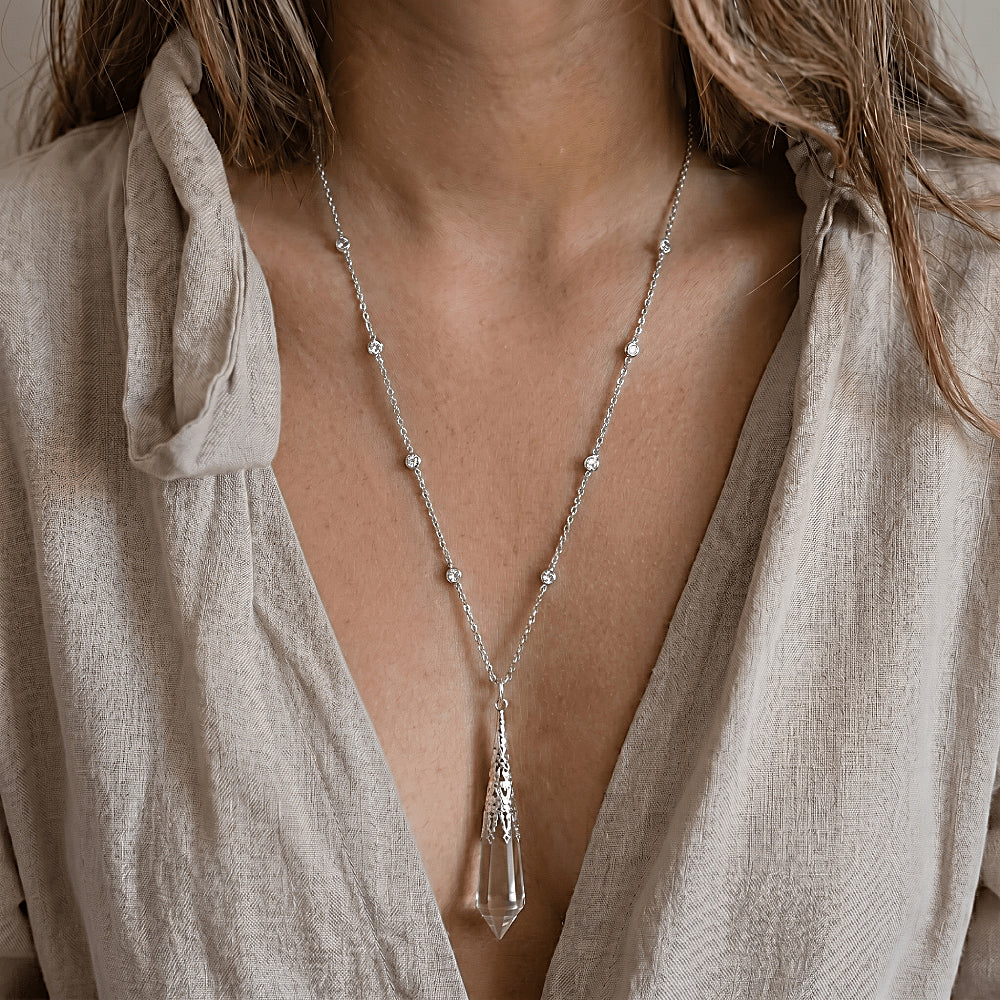 Discover the Oracle of Light Clear Quartz Crystal Pendulum Pendant at The Luxe Maison, featuring a faceted crystal designed for clarity, intuition, and timeless elegance.