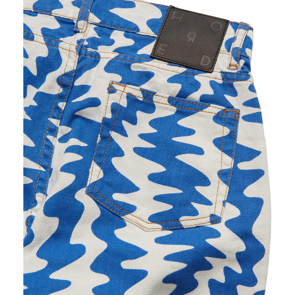 Horde Studio's Oren women's white jeans printed in a cerulean blue contrast pattern. Cut to a high-rise silhouette 