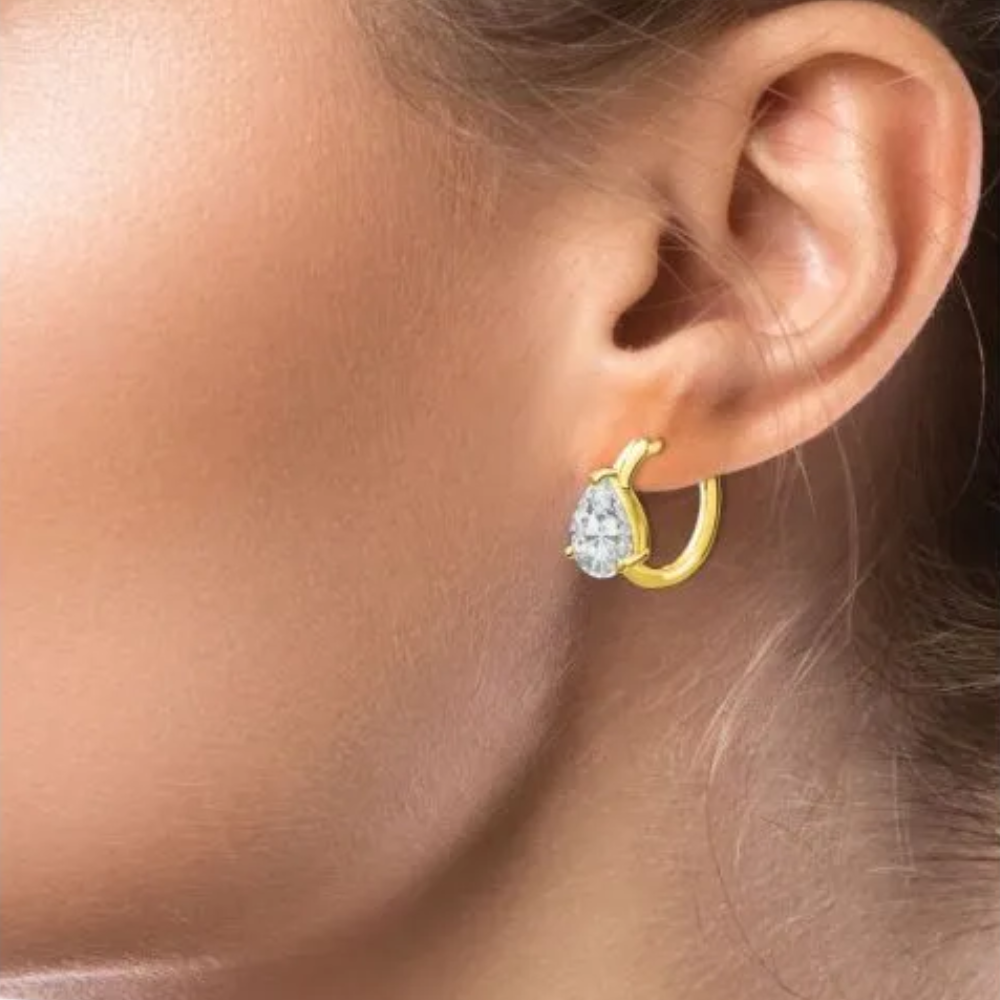 2CTTW pear cubic zirconia huggie hoop earrings. Snapback closure set in 18k gold plated brass.
