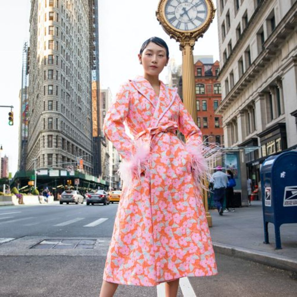 Pink coat has belted waist and decorated with detachable feathers cuffs.