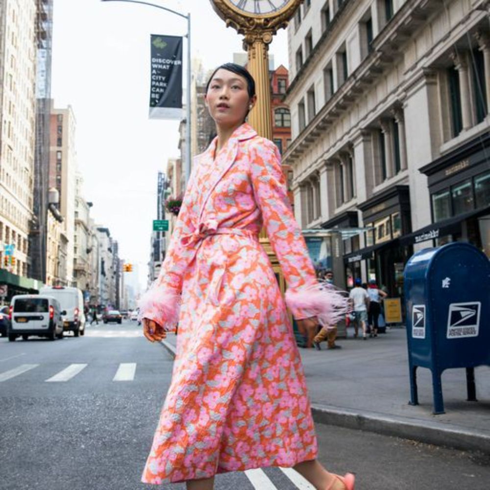 Pink coat has belted waist and decorated with detachable feathers cuffs.