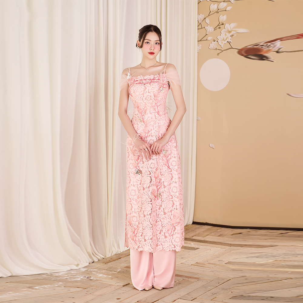 Explore designer dress shops for a stunning pink lace Ao Dai adorned with feathers. Elevate your style and make a statement! Shop Now!