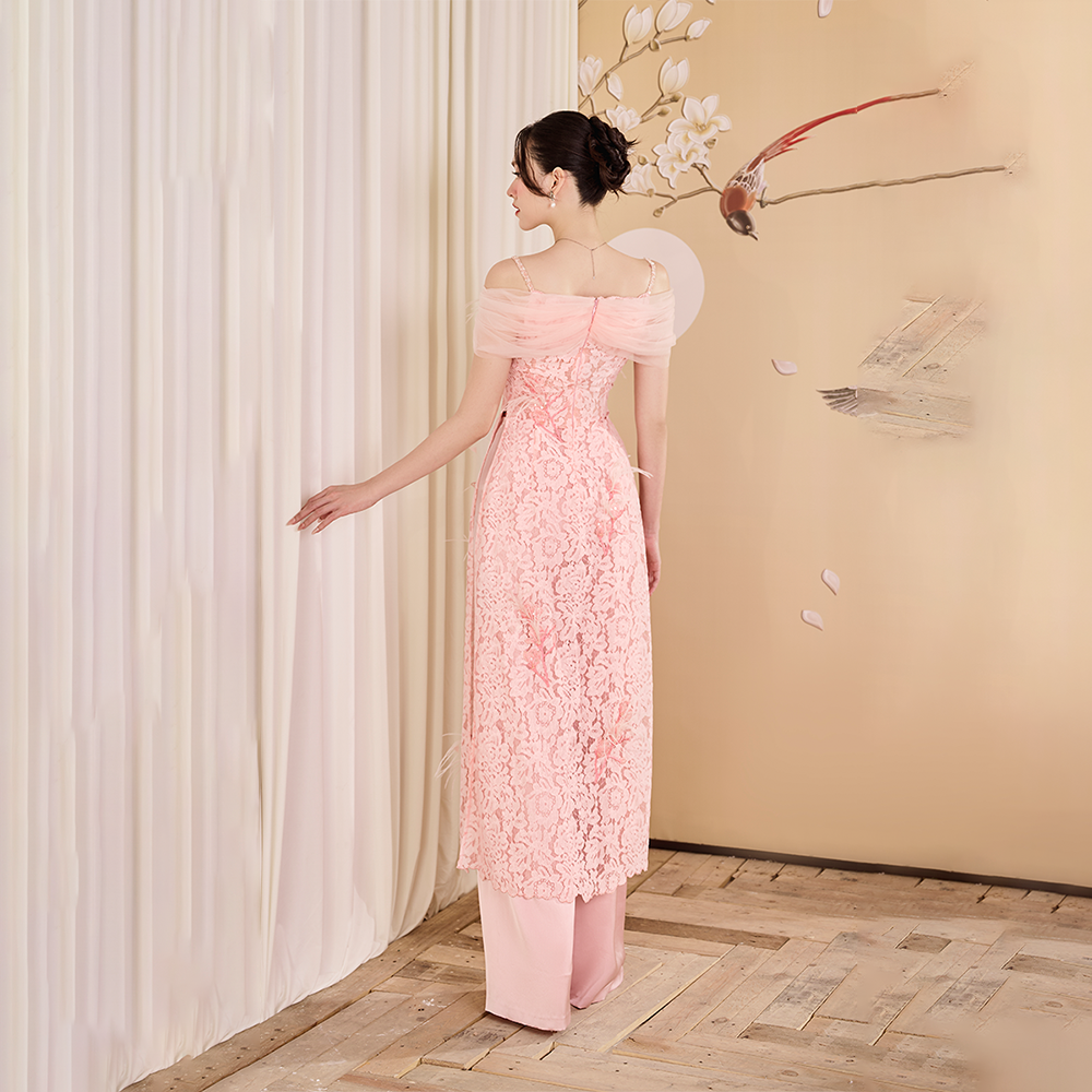 Explore designer dress shops for a stunning pink lace Ao Dai adorned with feathers. Elevate your style and make a statement! Shop Now!