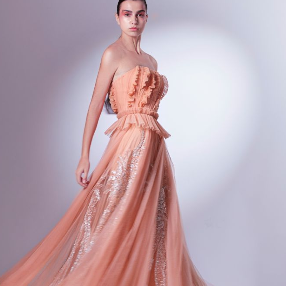 Designed in a daring coral color, this dress is carefully draped and pleated at the bodice, accentuating the waistline.