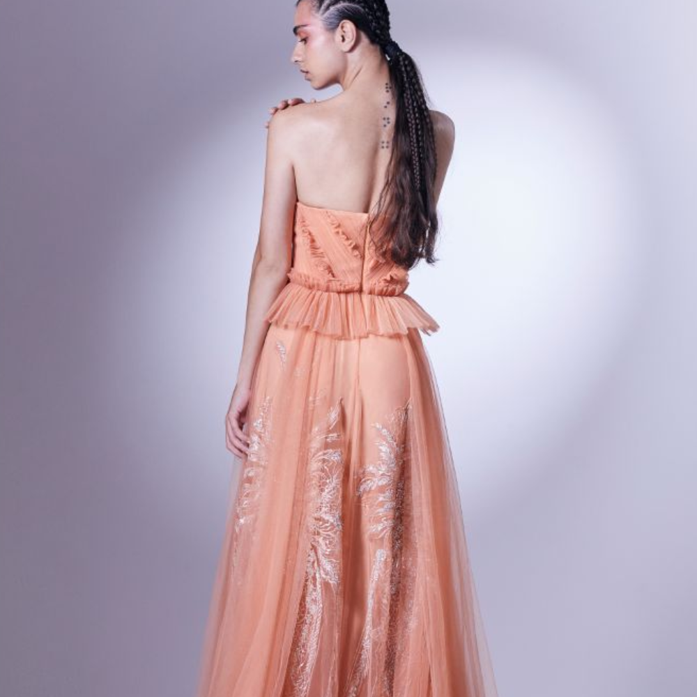 Designed in a daring coral color, this dress is carefully draped and pleated at the bodice, accentuating the waistline.