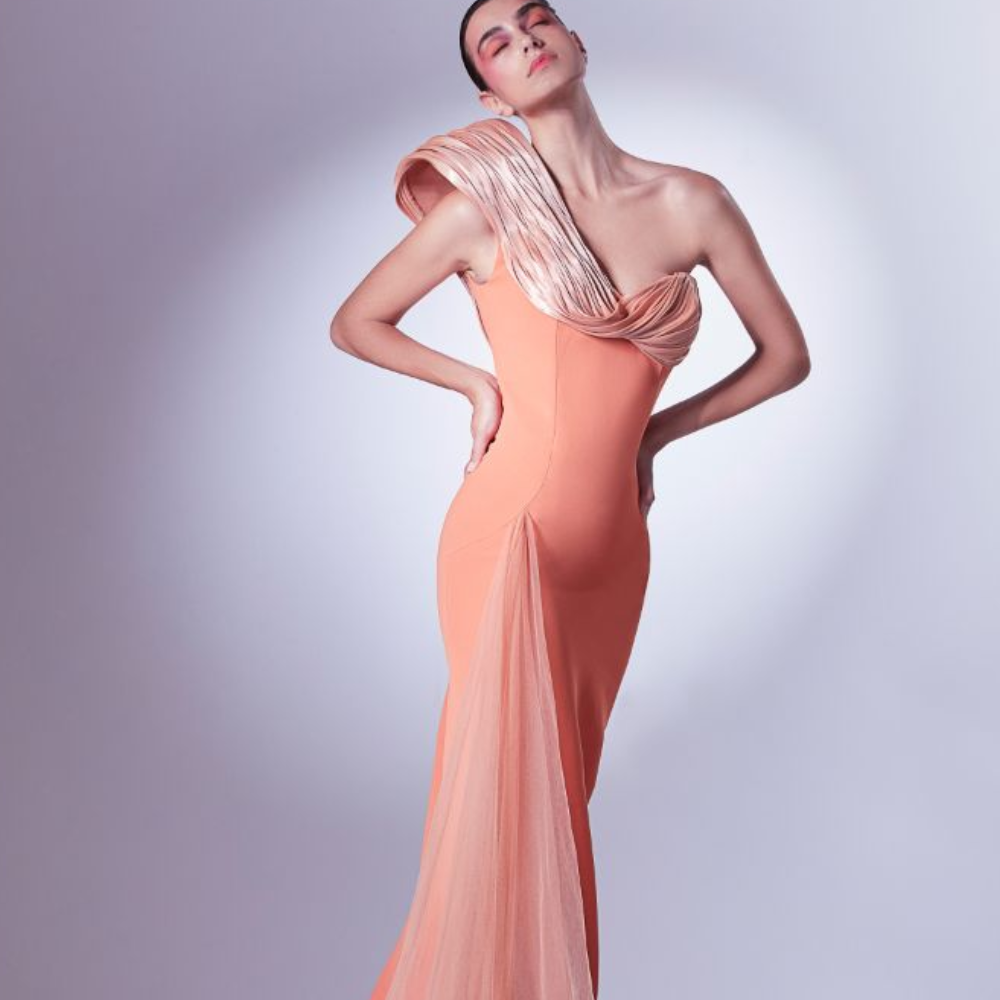 Tailored with sophistication, the vivid orange dress starts off with a ribbed organdie element at the shoulder.