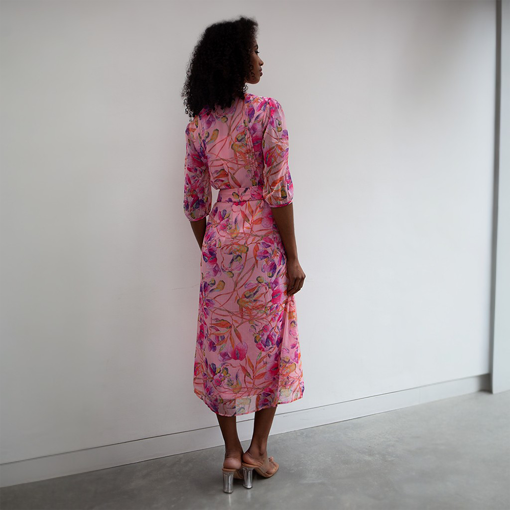 The Riley Dress has a midi-length pink floral pattern.