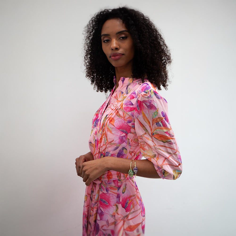 The Riley Dress has a midi-length pink floral pattern.