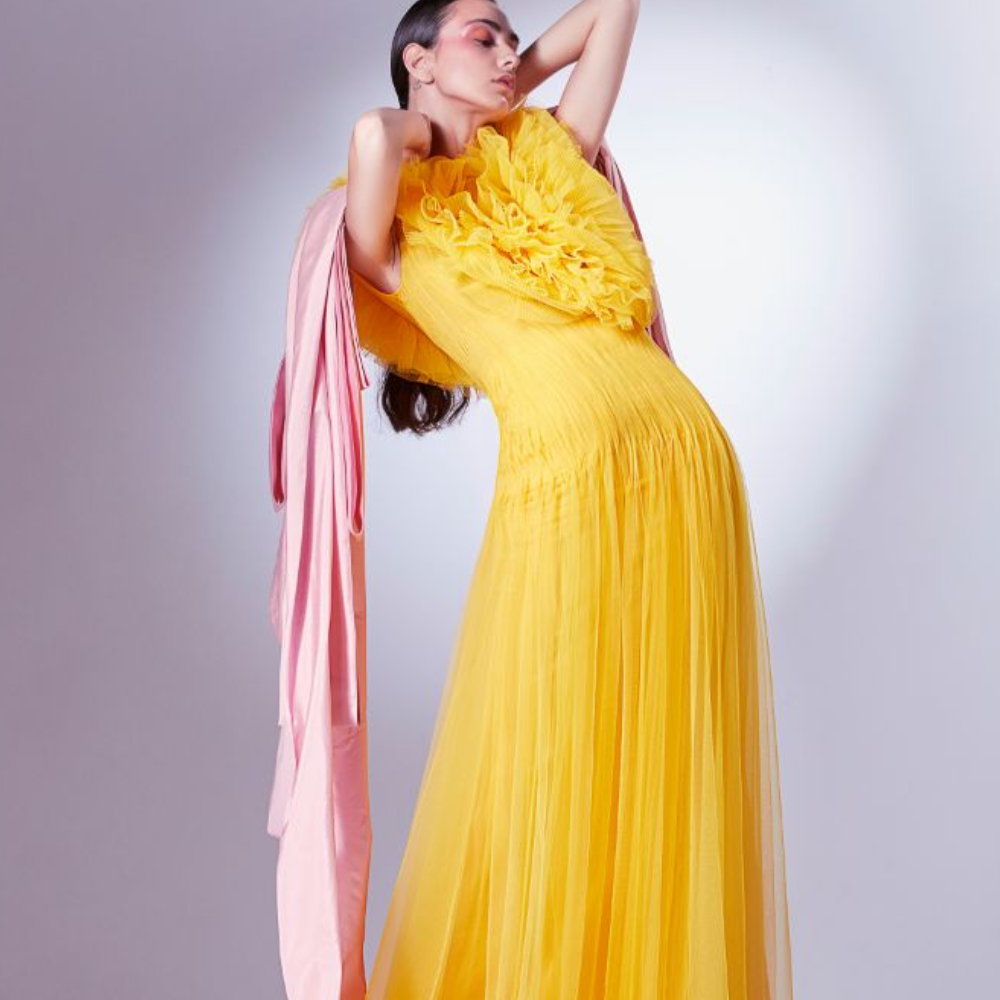 Rendered in a vibrant Mango yellow, it starts off with random chaotic frills of normal and pleated tulle at the bodice.