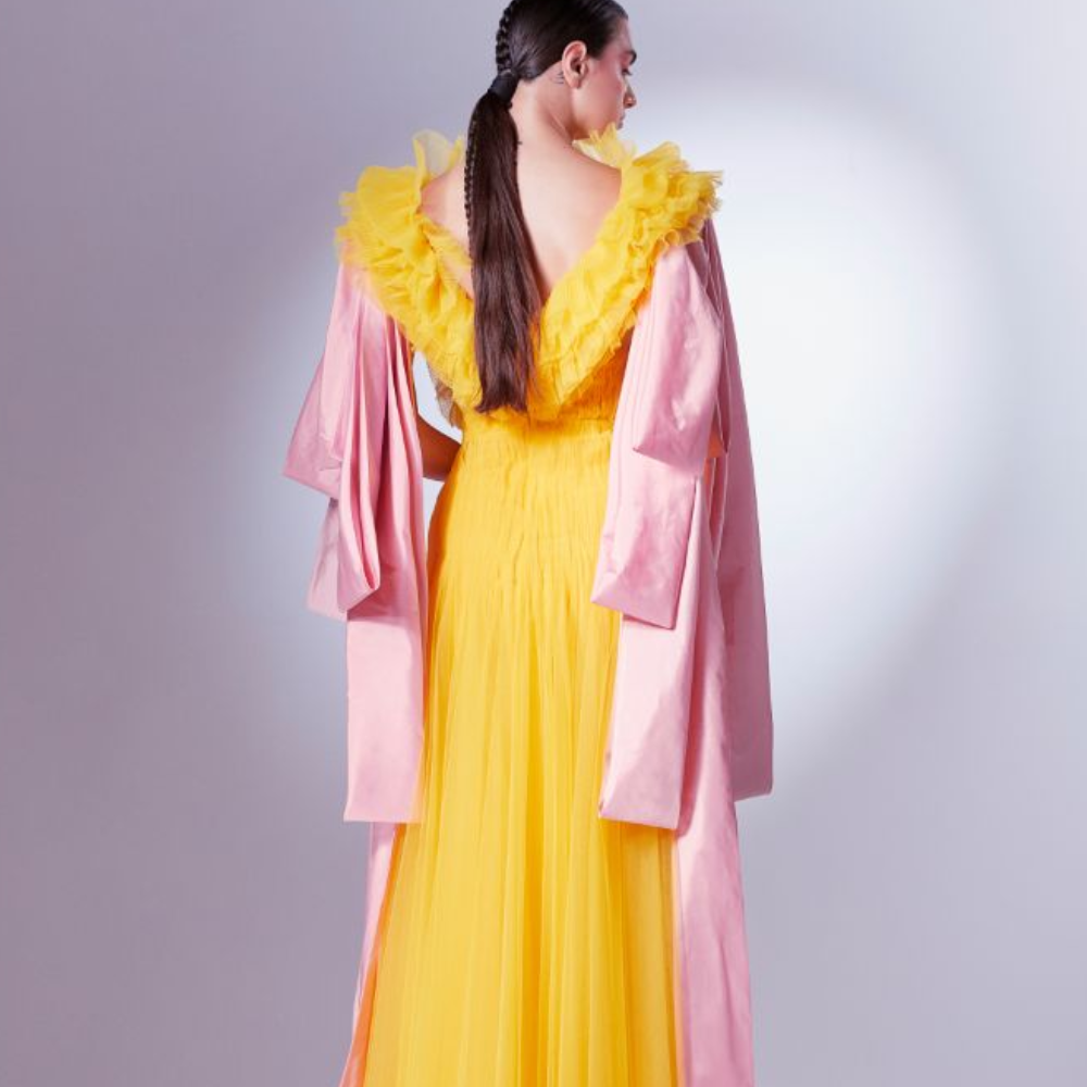 Rendered in a vibrant Mango yellow, it starts off with random chaotic frills of normal and pleated tulle at the bodice.