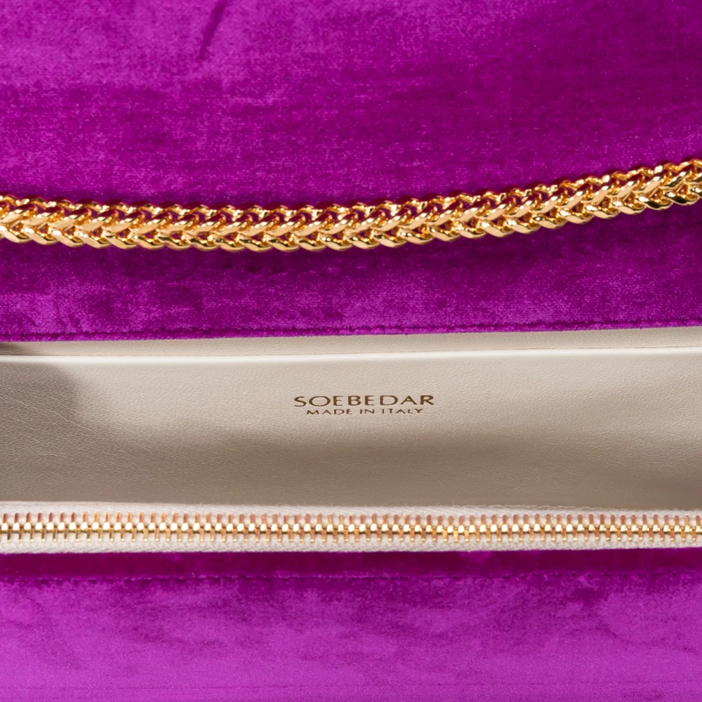 This velvet bag is hand-finished in Italy with gold plated hardware.