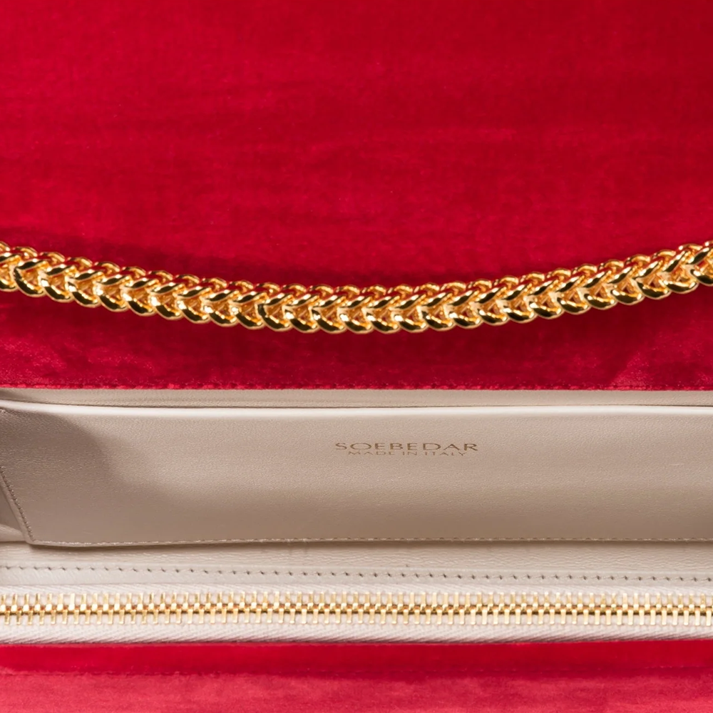 This velvet bag is hand-finished in Italy with gold plated hardware.