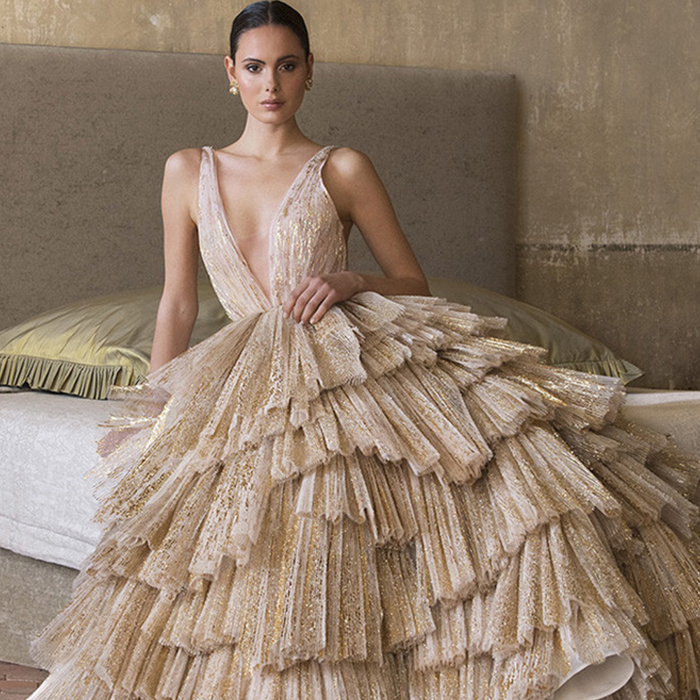 Bridal ball gown from iconic designer Peter Langner is a metallic pleated gold tulle asymmetric flounces and deep v neckline.