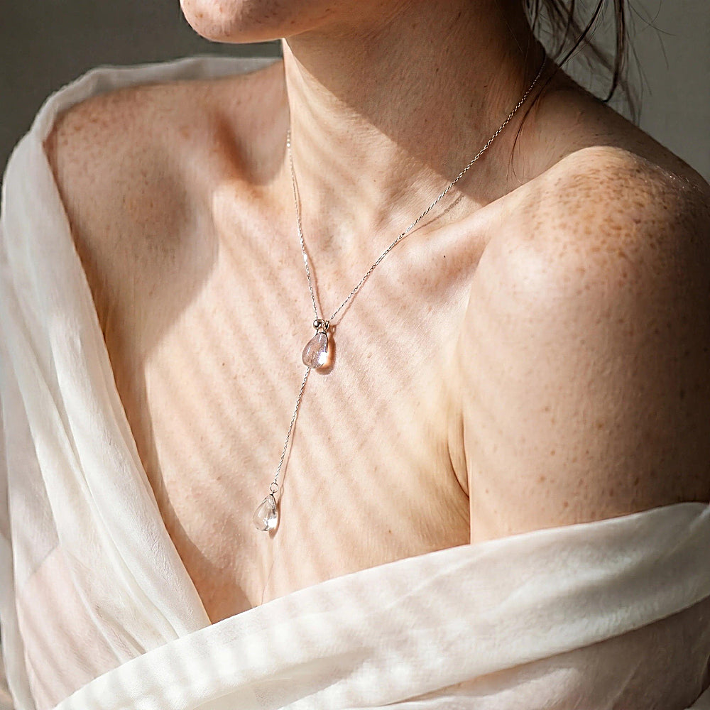 Discover the Silver Rain Lariat Necklace at The Luxe Maison, featuring crystal-clear glass pendants, a delicate chain, and an adjustable stainless steel clasp.