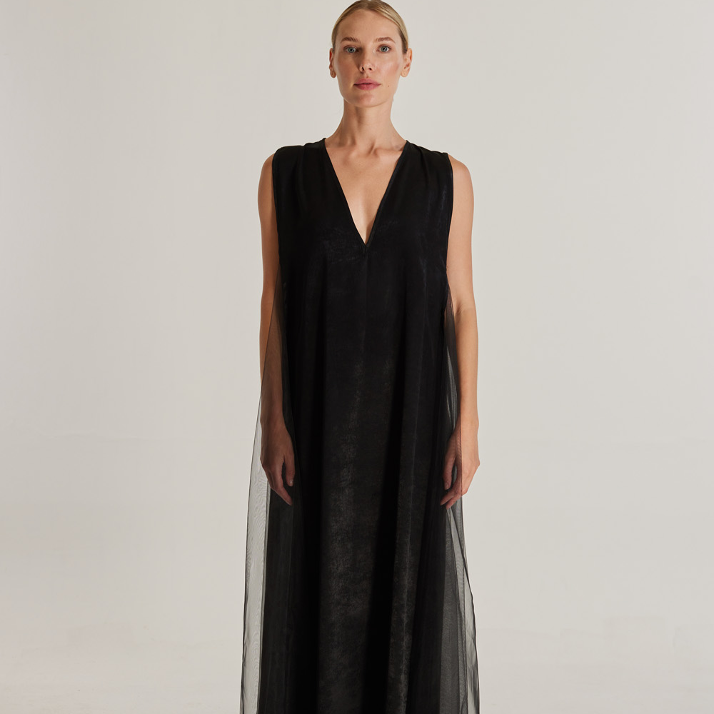 Sirocco is the name of the dress. It features a long and loose silhouette with a deep V-neckline.