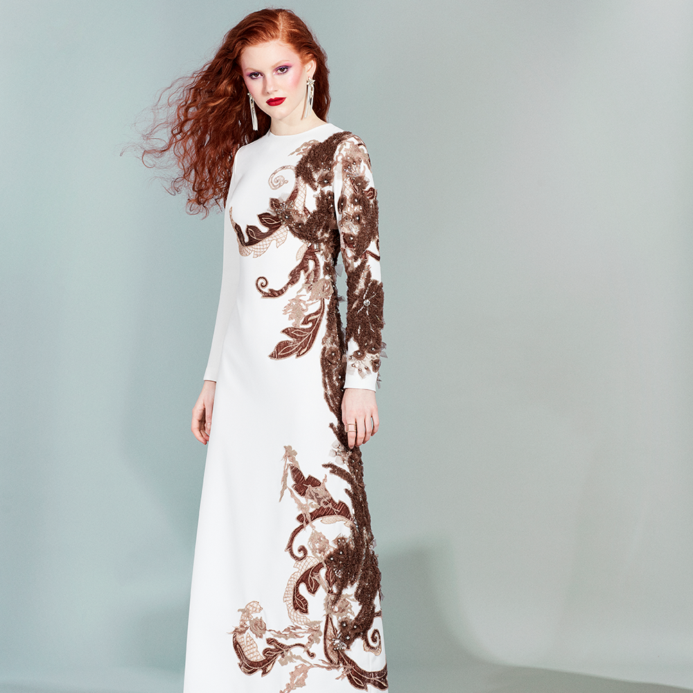 Long-sleeved ankle-length dress made of white crepe embroidered with velvet and tulle in shades of brown and beige.