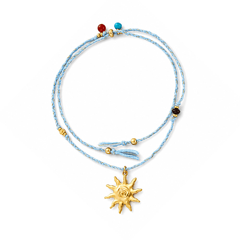 Discover the Solara Multi-Stone Cord Necklace at The Luxe Maison, featuring a radiant sun charm, vibrant natural stones, golden accents, and an adjustable sky-blue cord for a playful, sun-inspired look.