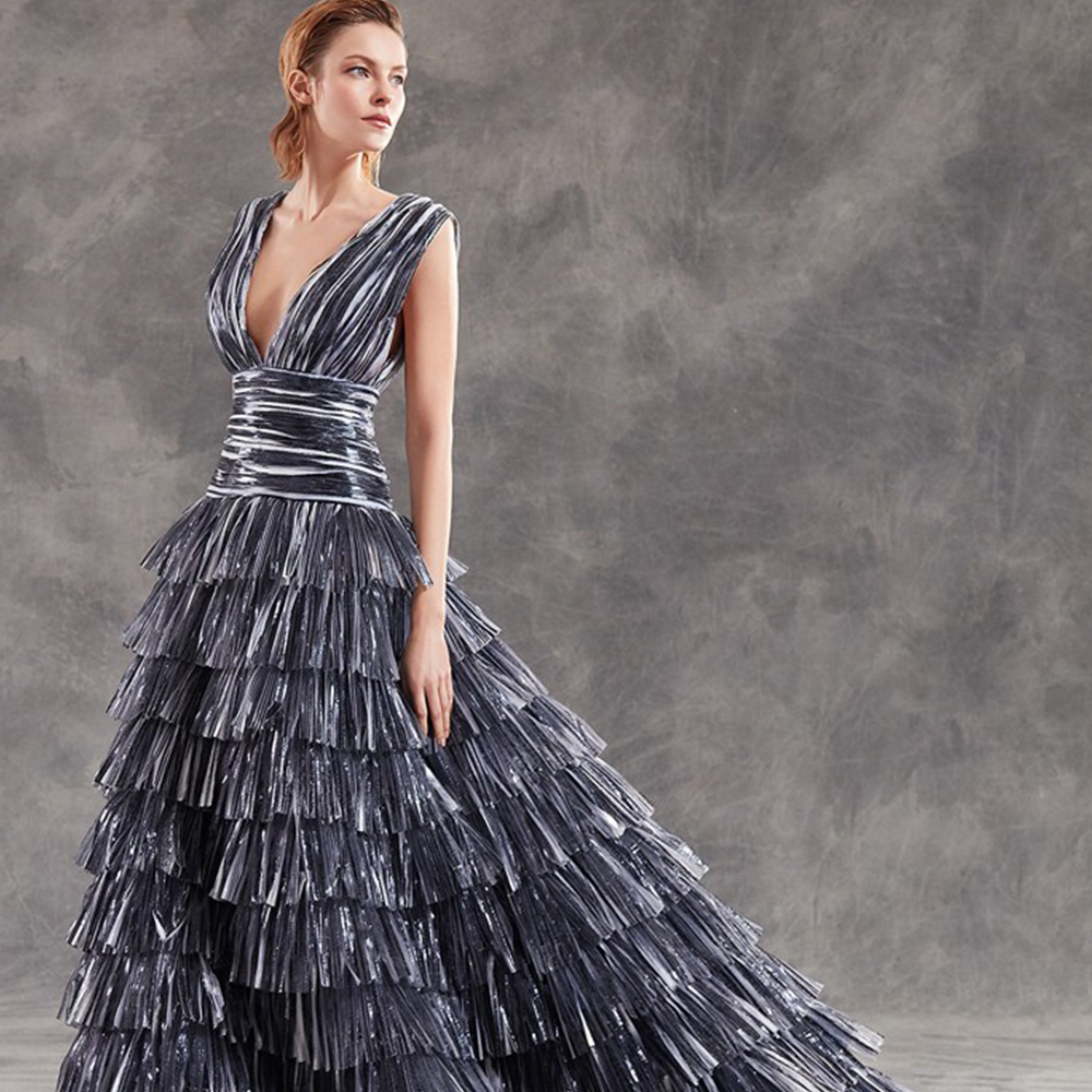 Ballgown in pleated laminated illusion tulle with deep v neckline.