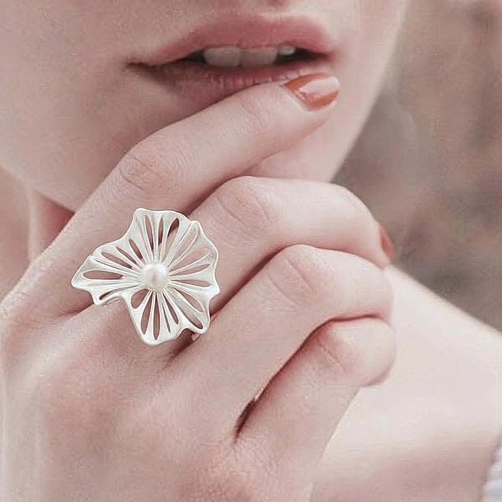 Discover the Spellflower Silver & Pearl Ring at The Luxe Maison, featuring delicate openwork silver petals with a soft matte finish and a luminous pearl centerpiece. With its ethereal floral silhouette and adjustable open band, this sculptural ring adds a touch of whimsical elegance to everyday style and special occasions.