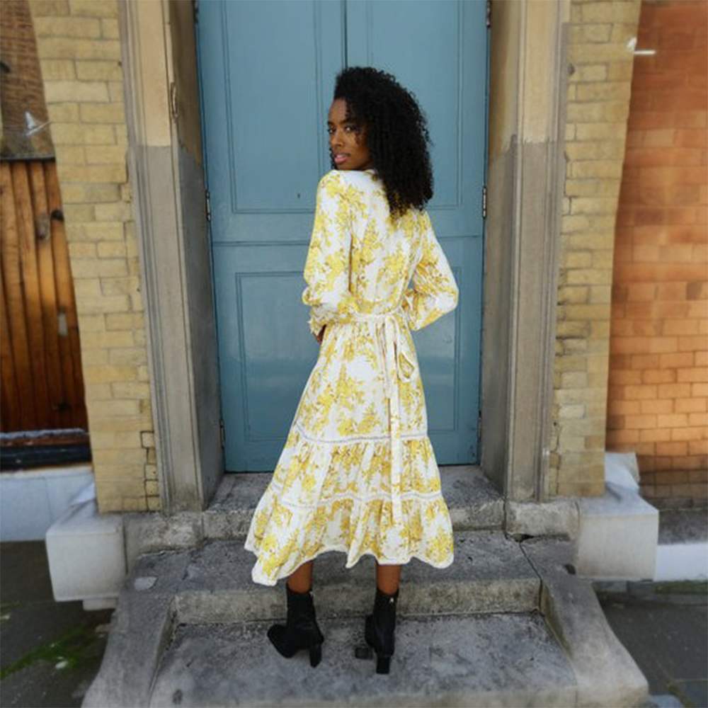 This stunning V neck wrap dress features a beautiful yellow print and has a tie at the waist for fastening.