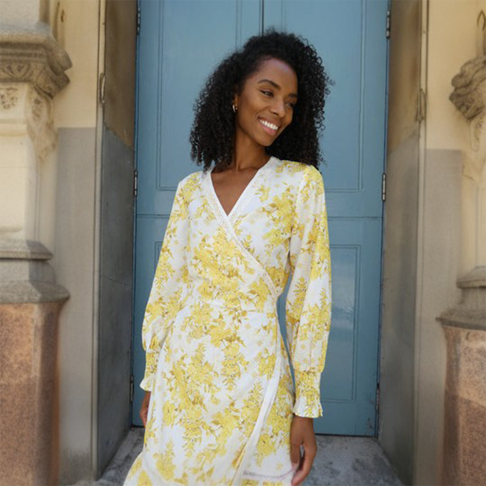 This stunning V neck wrap dress features a beautiful yellow print and has a tie at the waist for fastening.