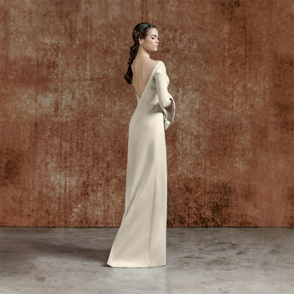 Beige long crepe dress with buttoning details and statement sleeves.