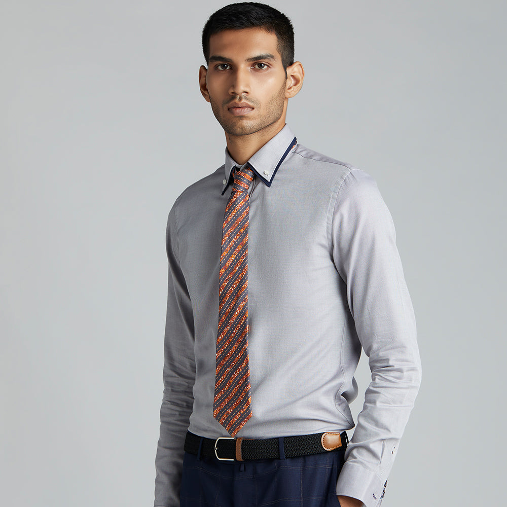 A sharp tie in terracotta, orange, yellow and grey, with a mixture of formal stripes and multi-colored background.