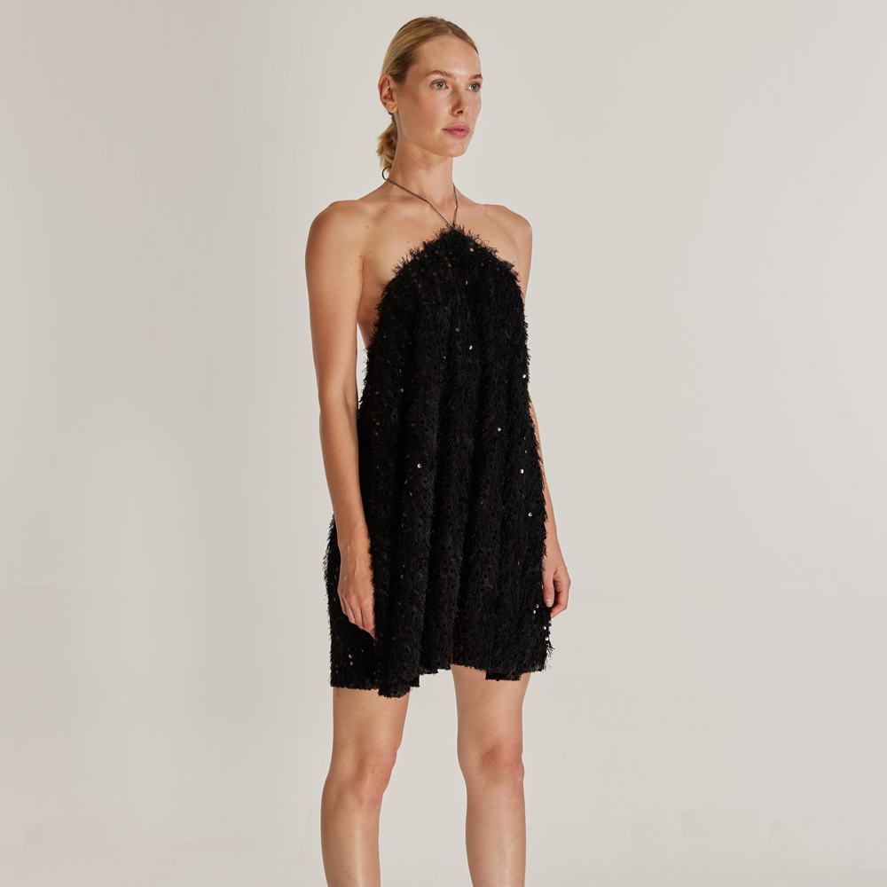 The Sunbeam Dress is a captivating mini dress made from sequined and tasseled black fabric. 