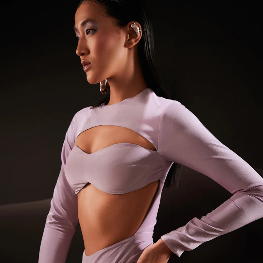 Glam up this season with our long sleeved crepe bodysuit in lilac featuring a cut-out on the upper bust and a bare waist.