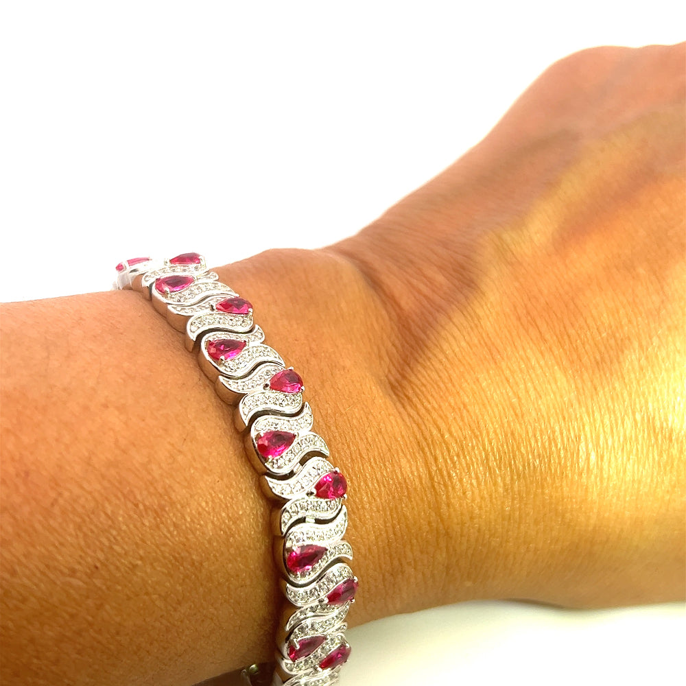 Sterling silver bracelet with lab-created ruby stones and sparkling cubic zirconia for a bold timeless look. Shop premium jewelry online.