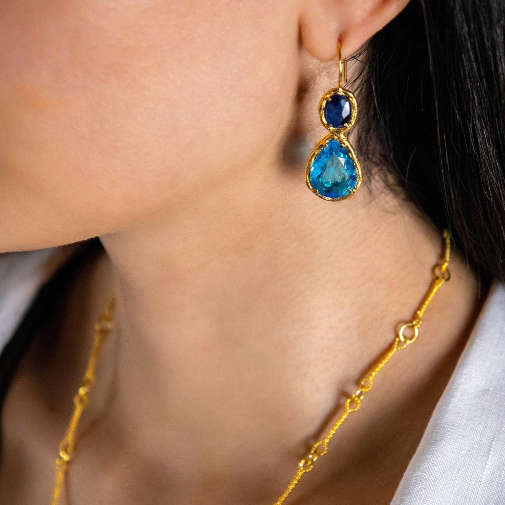 The Drop Earrings with 22K Gold Vermeil surrounding drop-shaped Blue Topaz with Tanzanite & Zircon attached is exclusively on Luxe Maison. Shop now!