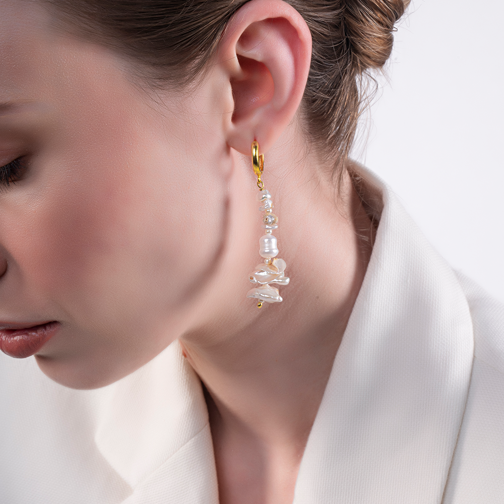 These exquisite earrings feature an array of different-sized pearls, symbolizing the ever-changing movement of the sea.