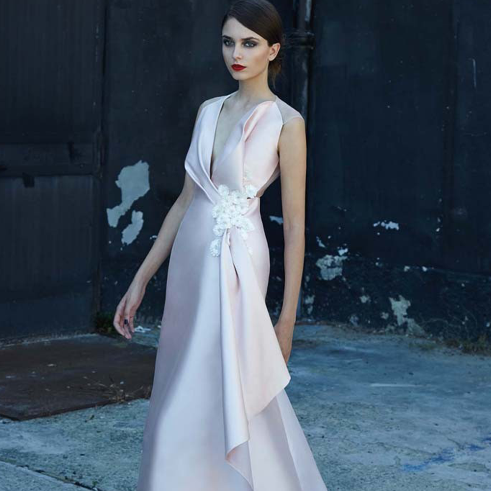 Sheath gown in mikado embroidered with raffia flowers on the neckline, illusion tulle back.