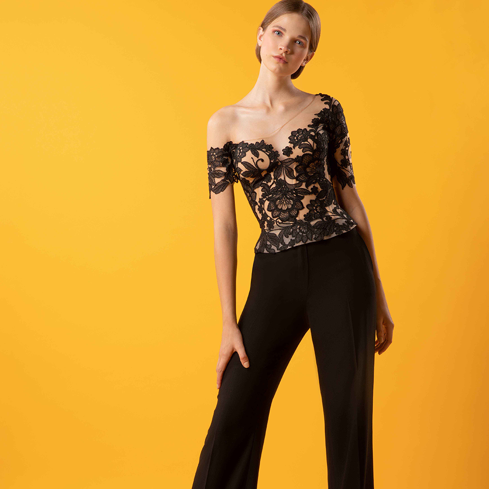Asymmetrical floral laced top paired with wideleg crepe pants.