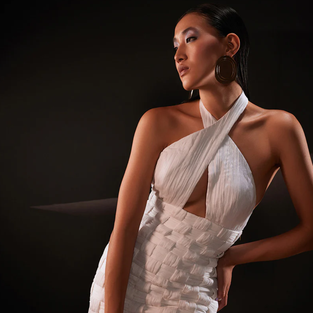 Enchanting statement dress in white chiffon centered by a ruched cross halterneck bustier bodice.